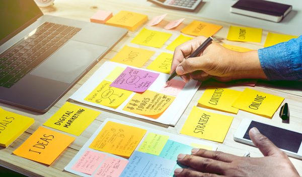 Desktop filled with post-it notes working on cornerstone pages